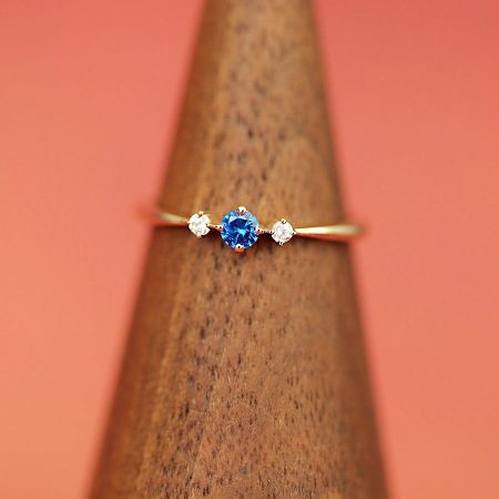 De sterling zilveren geboortesteenring tentoongesteld op een houten standaard voor een gedetailleerd uitzicht.