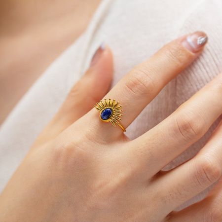 Roestvrijstalen blauwe lapis lazuli zonnestraal verstelbare ringen (set van 5) - Een close-up van een verstelbare roestvrijstalen ring met een gouden afwerking, met een centrale blauwe Lapis Lazuli steen in een zonnestraalinstelling.
