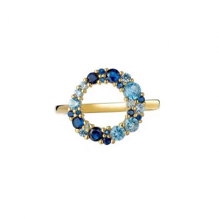 Nahaufnahme eines zarten vergoldeten Rings mit einem zentralen blauen CZ, umgeben von kleineren klaren Steinen.