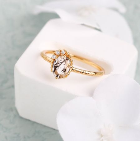 Der vergoldete Sterlingsilberring mit einem auffälligen Salz- und Pfeffer-Gemstein, elegant in einer weißen Schmuckschatulle präsentiert.