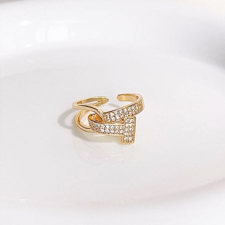 Vista detallada de un delicado anillo chapado en oro adornado con piedras claras brillantes.