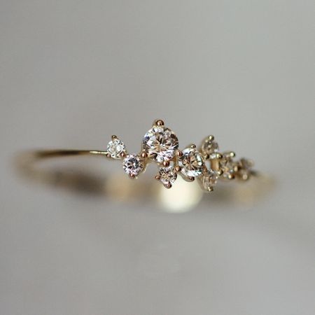 Gedetailleerd uitzicht op een vergulde sterling zilveren ring met een cluster van sprankelende cubic zirconia.