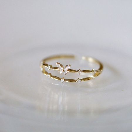 Bague papillon ajustable en argent sterling 925 - Un gros plan de la bague papillon ajustable en argent sterling 925 avec une finition dorée, mettant en valeur le design détaillé du papillon et les pierres en zircon cubique étincelantes.
