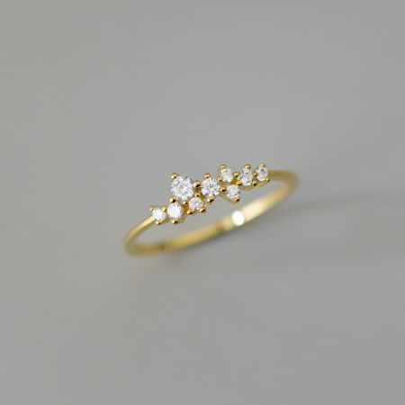 Een stijlvolle vergulde ring die een uniek clusterontwerp van cubic zirconia stenen toont.