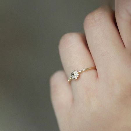 A model wearing the gold snowflake ring, demonstrating its elegant fit and sparkling appearance on the hand.
