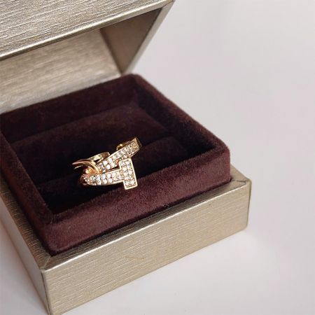 Un lujoso anillo de zirconia chapado en oro del conjunto, presentado en una elegante caja de joyería.