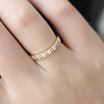 Vue en gros plan de la bague minimaliste en zircon creux doré sur un doigt.
