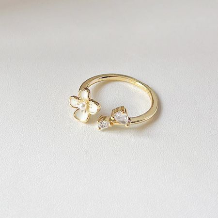 Gold ring with a delicate flower and sparkling zircon stone design.
