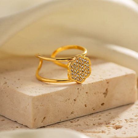 Um anel banhado a ouro lindamente elaborado com uma decoração floral, parte do conjunto de cinco peças.