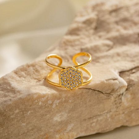 Imagem detalhada de um anel de ouro com um intrincado centro em forma de flor de zircônia cúbica.