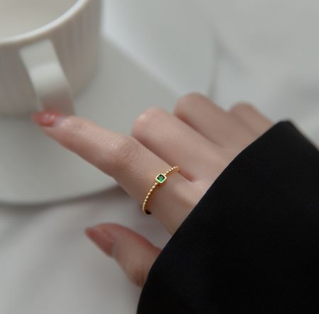 Bague en argent sterling 925 en gros avec émeraude - Bague en argent sterling 925 en gros avec finition dorée, présentant un zircon cubique taille émeraude de couleur verte vibrante. Proposé par JR Fashion Accessories.