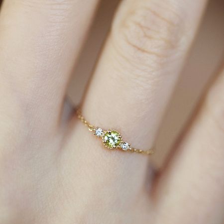 Detaljerad studiofotografi av 925 sterling silverringen med en ljusgrön ädelsten och diamantaccenter.