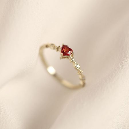 Set di 5 anelli in argento sterling 925 a forma di cuore con rubino rosso - Un primo piano di un anello in argento sterling 925 con finitura dorata, con un brillante rubino rosso a forma di cuore al centro, da JR Fashion Accessories.