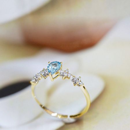 アクアマリンリングの詳細なビューで、ゴールドバンドとサイドストーンのディテールを強調。