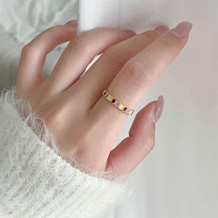 Modell trägt den verstellbaren Ring aus 925er Sterlingsilber mit buntem geometrischem Emaille, der seine Alltagstauglichkeit zeigt.