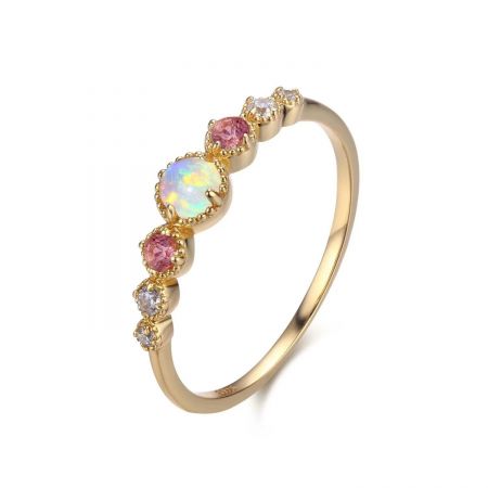 Detailaufnahme des vergoldeten Rings, der den lebhaften rosa Zirkon und den zentralen Opal hervorhebt.