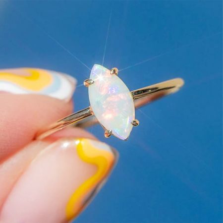 金仕上げのバンドにセットされた虹色のマルキーズオパール石のクローズアップ。