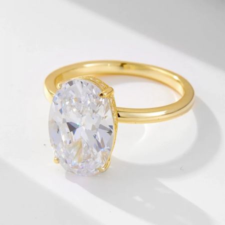 Un primo piano di un anello d'oro straordinario con una grande pietra in zirconia cubica trasparente a taglio ovale in una classica montatura a quattro artigli.