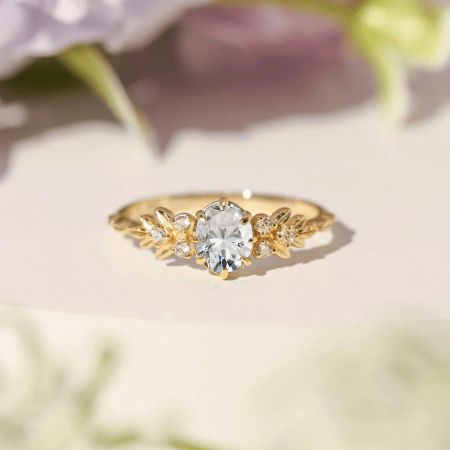 Toma en ángulo del anillo que muestra el engaste inspirado en flores y las piedras de acento brillantes.