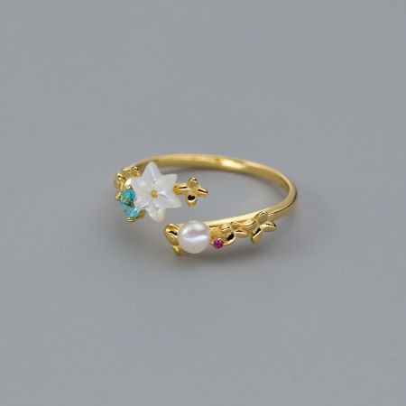 真珠と花の石が付いたスターリングシルバーの金メッキ指輪の詳細ビュー。