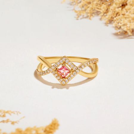Vista lateral del anillo de plata dorada con cristal rosa y strass.