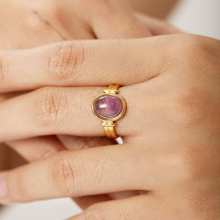 Roestvrijstalen amethist cabochon edelstenen open ringen (set van 5) - Een close-up van een goudafgewerkte roestvrijstalen open ring met een gepolijste paarse amethist cabochon edelsteen, op een schone witte achtergrond.