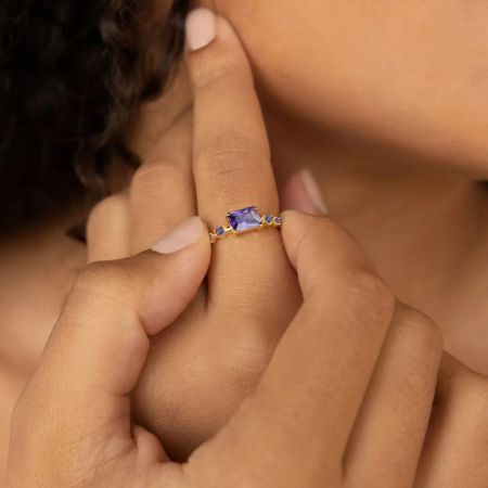 Detailed view of the purple baguette-cut CZ promise ring in 925 sterling silver with gold plating.