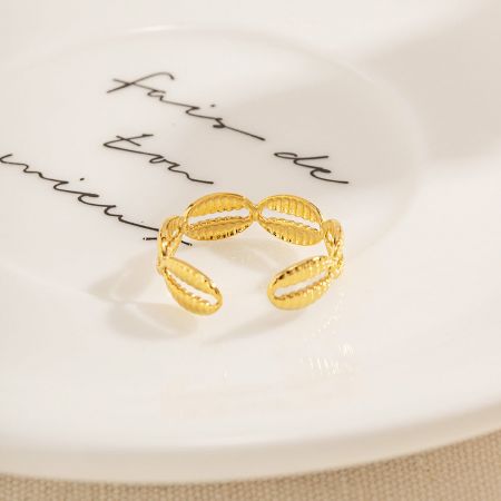 Een unieke textuur ovalen ontwerp gouden ring uit de set van vijf, op een decoratief bord.