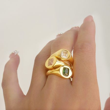 Een enkele ring die drie verschillende gekleurde vierkante edelstenen toont.