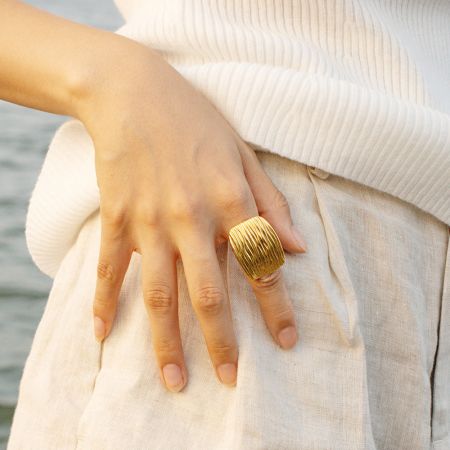 目立つ縦のリッジがあるゴールドのジオメトリックリングで、ボールドな印象。