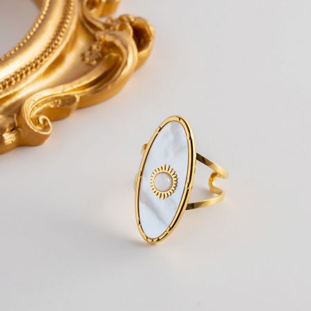 Une autre vue de la bague en or au design en rayons de soleil avec incrustation en nacre blanche.