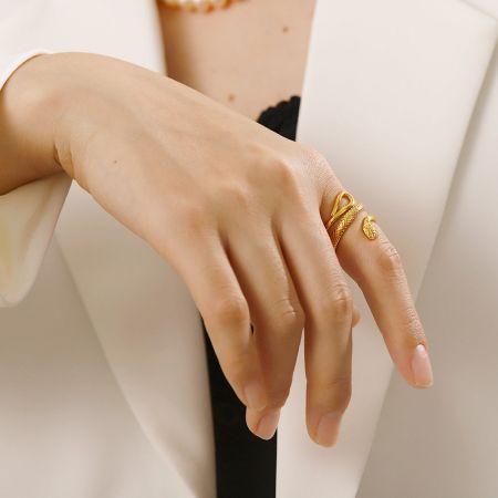 Lifestyle afbeelding van de gouden slangring op de hand van een vrouw, die de modieuze aantrekkingskracht benadrukt.