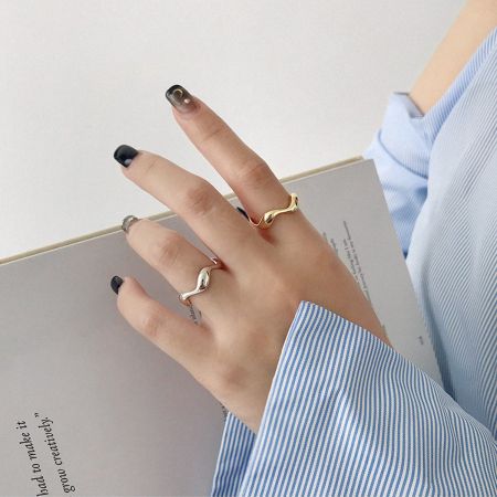 Model die de set van minimalistische verstelbare ringen van 925 sterling zilver draagt voor een gestapeld uiterlijk.