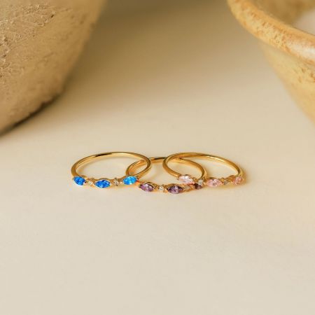 A close-up of three 925 sterling silver birthstone rings with vibrant gemstones.