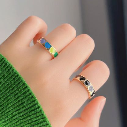 The adjustable gold-plated enamel rings worn on a mannequin's hand to show scale.