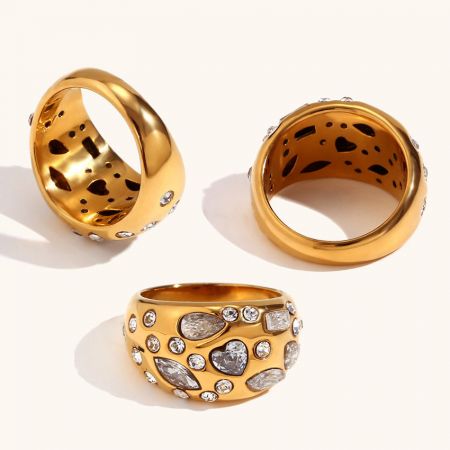 Een collectie van drie vergulde pave zirkon ringen, die variaties in de set toont.