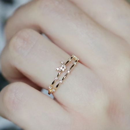 モデルが調整可能なダブルレイヤーバタフライリングを着用し、そのエレガントなフィット感を示しています。