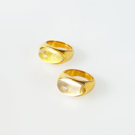 Een paar roestvrijstalen ringen met levendige gele ovale edelstenen, die de kleurvariëteit van de set toont.
