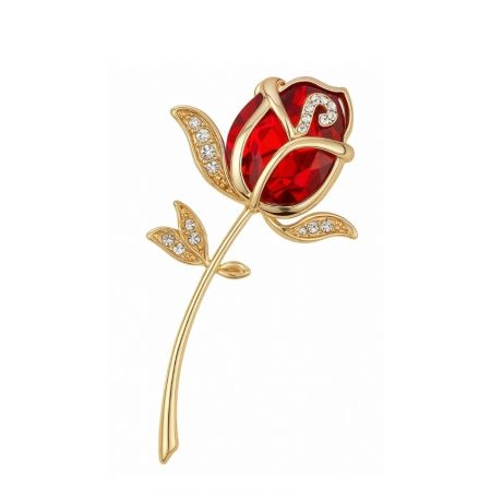 Broche de rosa dorada clásica con una gema roja central.