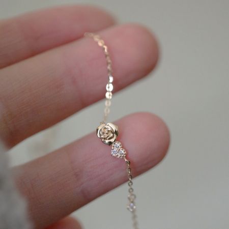 Close-up of the gold-plated bracelet showcasing the detailed rose charm and zirconia accent.