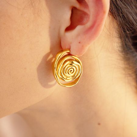Primer plano de una mujer que lleva los pendientes de espiral de oro, mostrando su aspecto elegante.