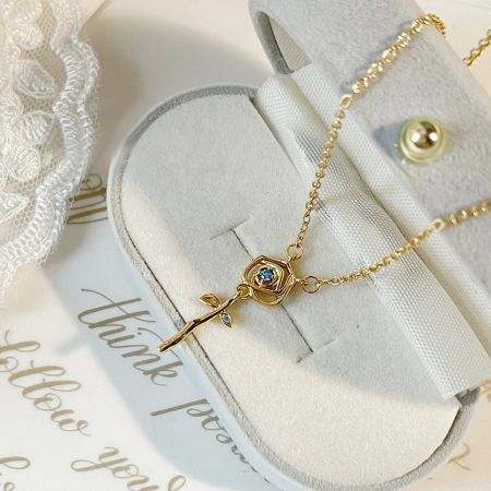 Fashion Gold Plated Zirconia Rose Flower Pendant Necklaces - A stunning gold-plated rose flower pendant necklace with blue zirconia, part of a set of five, elegantly displayed on a white bust.