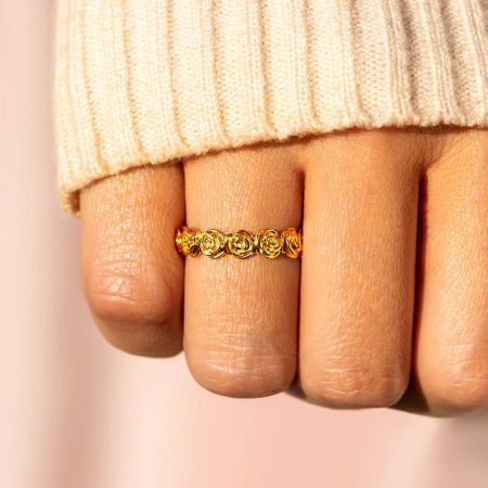 エターナルブルームのリングの豪華な金メッキと連続したバラのバンドデザインのクローズアップ。