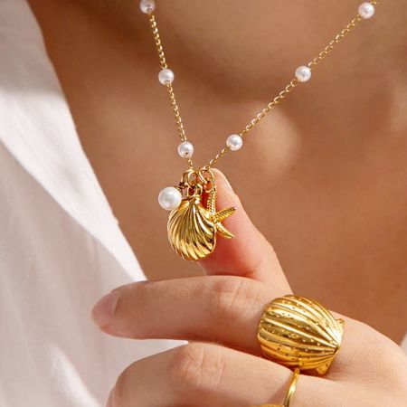 Eine weitere Ansicht der goldenen Muschel- und Seestern-Halskette, kombiniert mit dem passenden Muschelring.