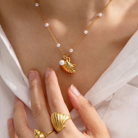 Das komplette Strand-Schmuckset, einschließlich der goldenen Muschel-Halskette und einem passenden Ring.