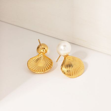 Vista frontal de los aretes de perla con concha de oro.