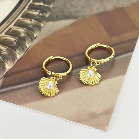 Vista dettagliata dell'orecchino a pendente a conchiglia in argento sterling 925 con una perla centrale.