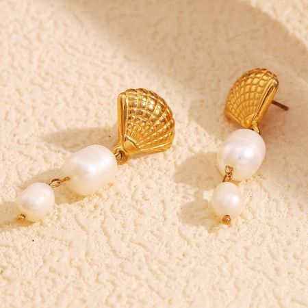 Close-up shot of the gold stainless steel earrings, emphasizing the shell-like design and lustrous white pearls.