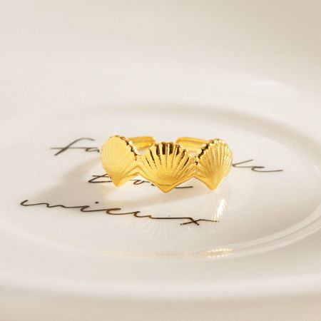 De schelp ring elegant weergegeven op een decoratief bord.