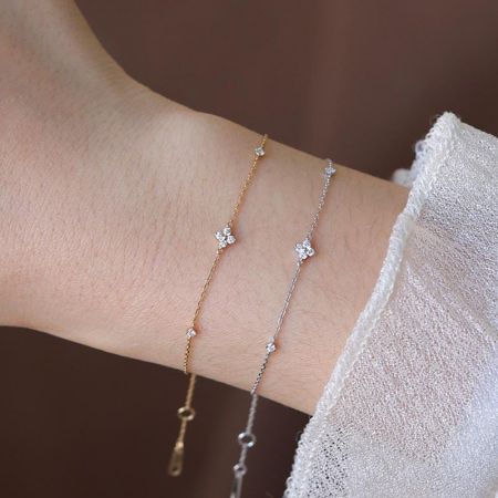 A versatile set showing both gold and silver plated bracelets with sparkling bow-shaped charms.